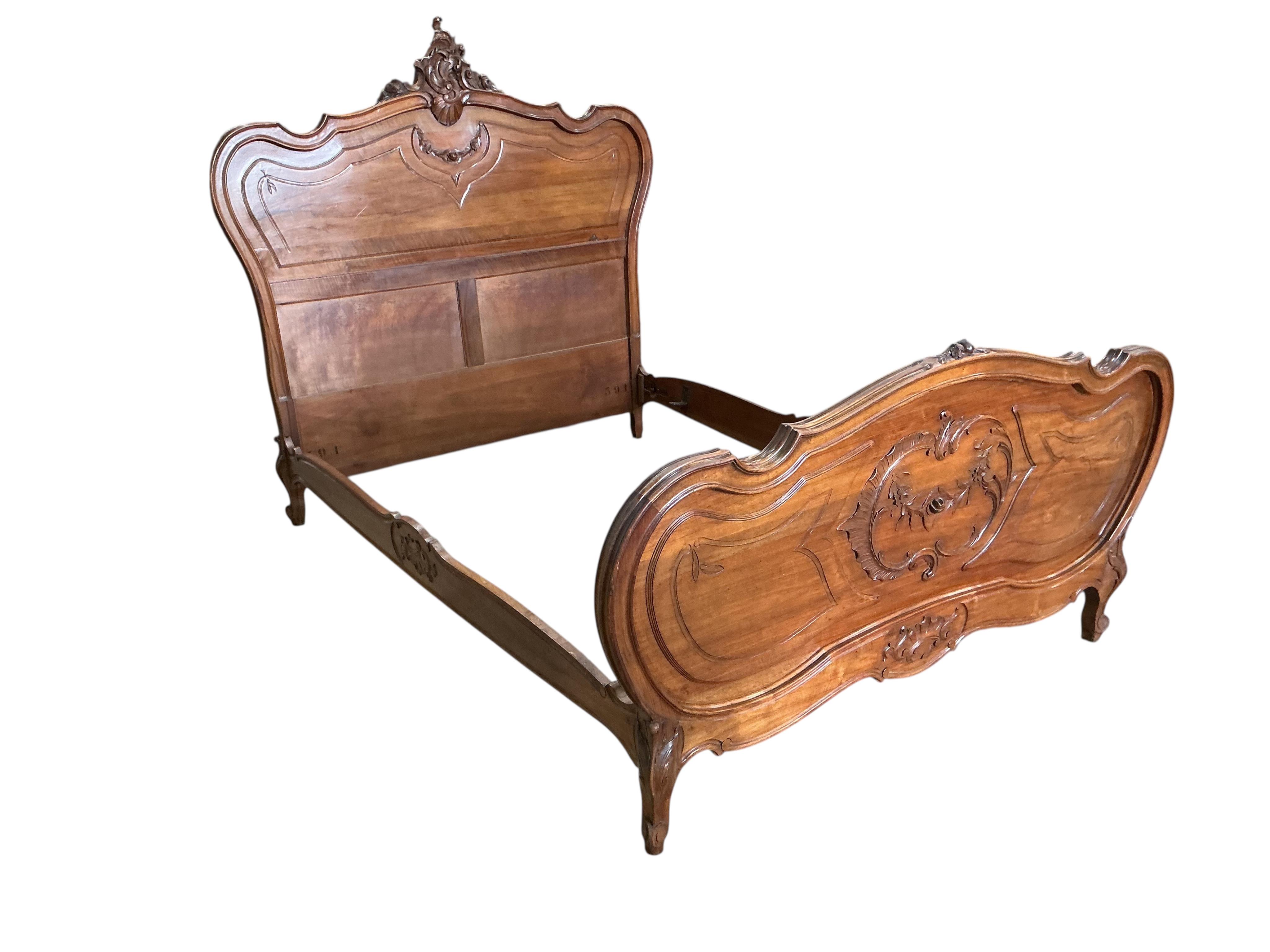 An early 20th century Louis XV style carved walnut bedframe, width 143cm, length 204cm, height 156cm